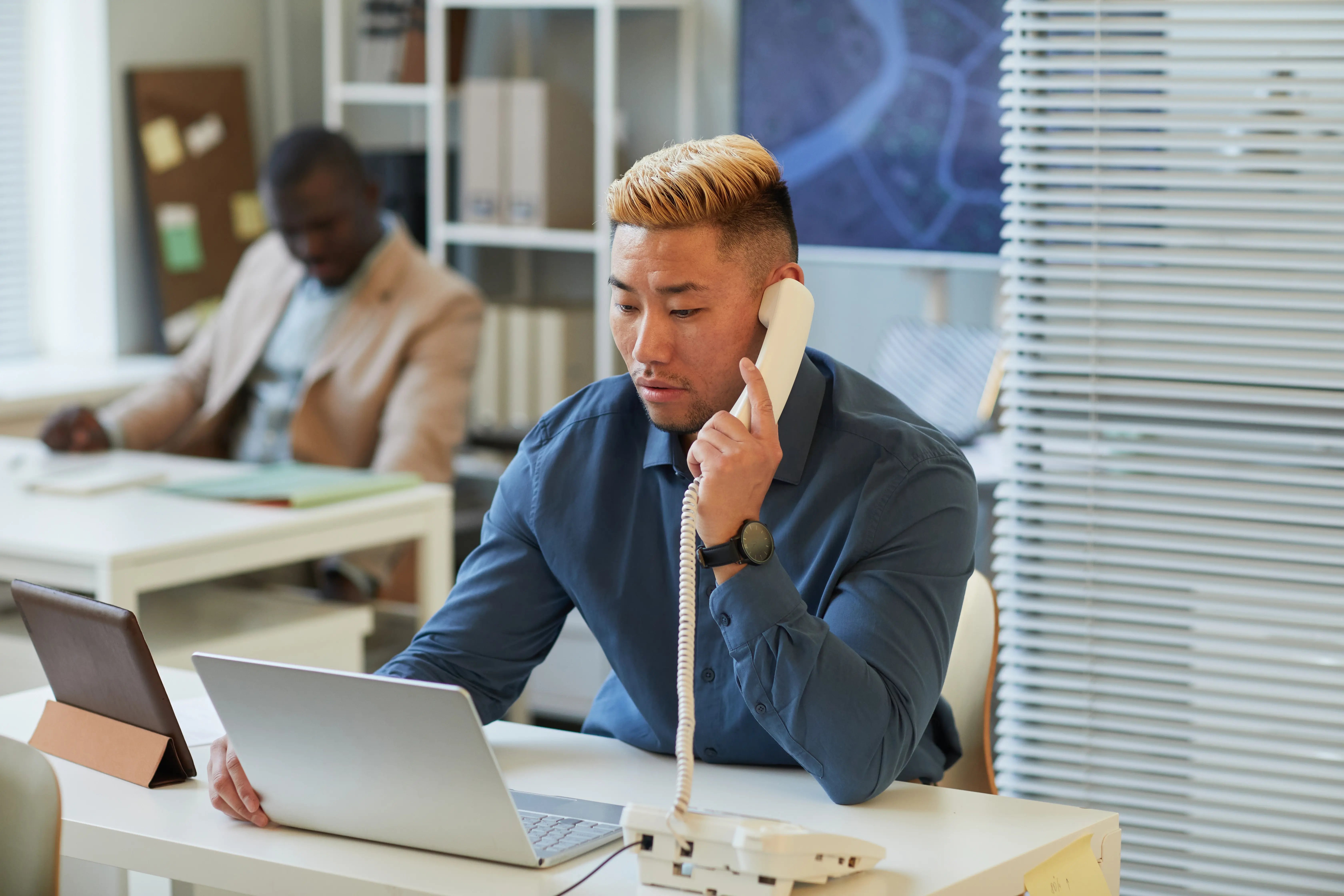 focused-man-working-and-talking-on-phone-at-desk-2026-01-08-07-35-22-utc