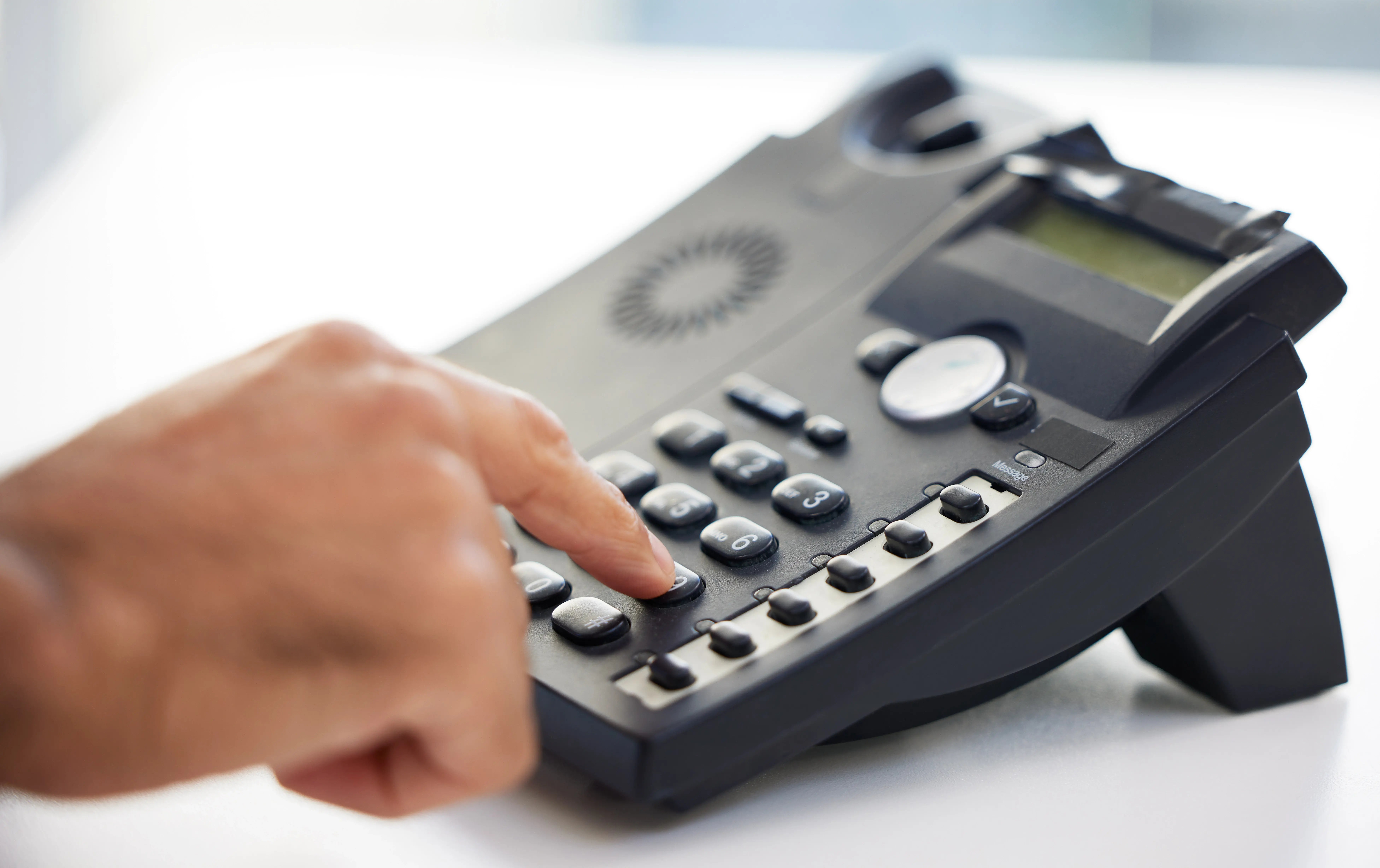 hand-dialing-number-on-black-modern-office-phone-2026-01-09-11-33-14-utc